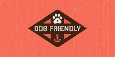Orange and brown graphic featuring a paw print and an anchor with the words, 'DOG FRIENDLY' 