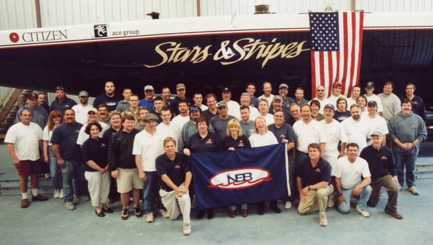 NEB Team in front of Stars & Stripes that raced in Auckland, NZ 2000 Tom Rich on the right of the NEB flag front row